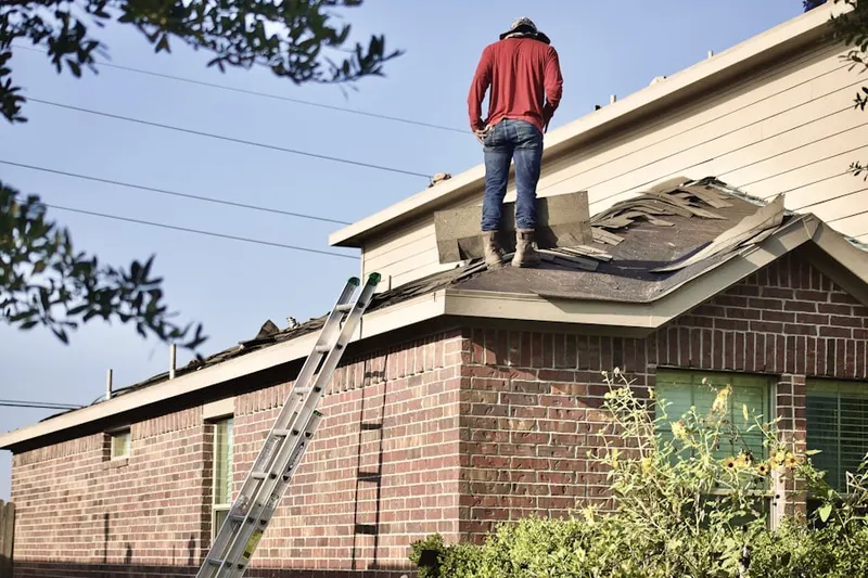 Professional roofer working on a residential roof in Houck Manor
